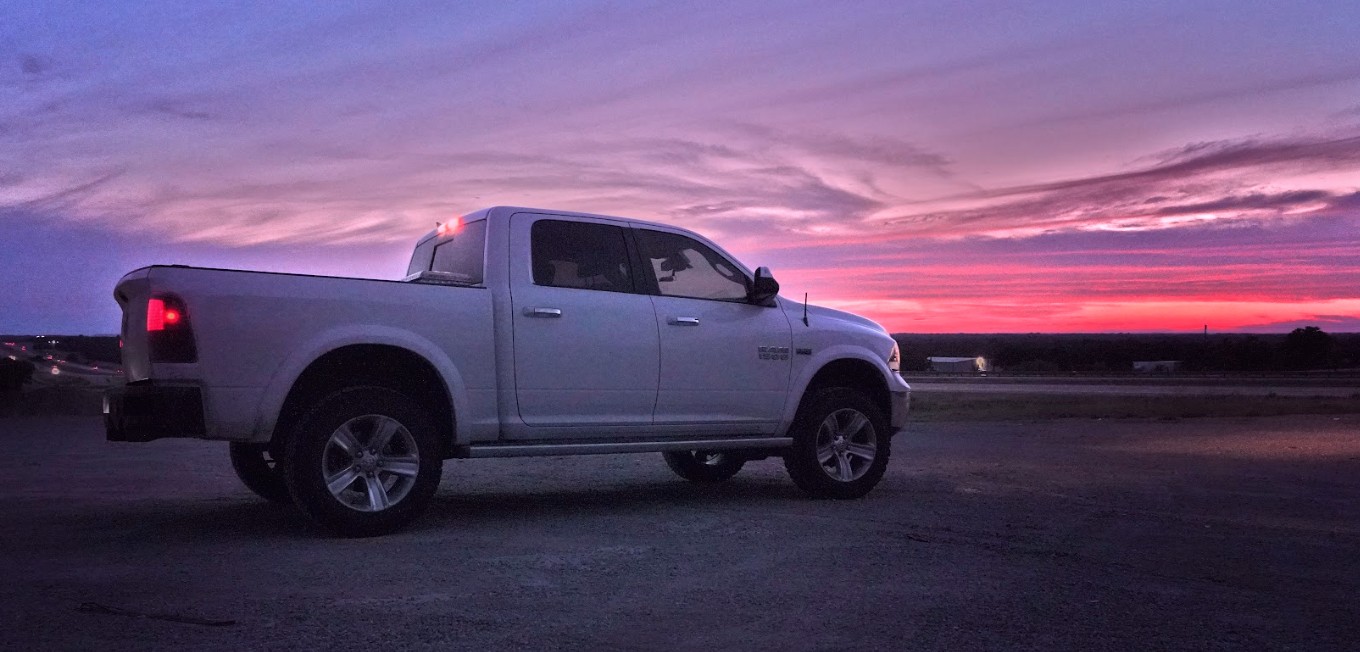 A customized off-road truck parked on a ridgeline during a golden hour sunset, symbolizing the freedom of the outdoor lifestyle.